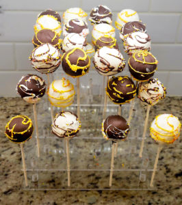 Assortment of chocolate and vanilla cake pops decorated with intricate designs and sprinkles, created by Cake Coma.